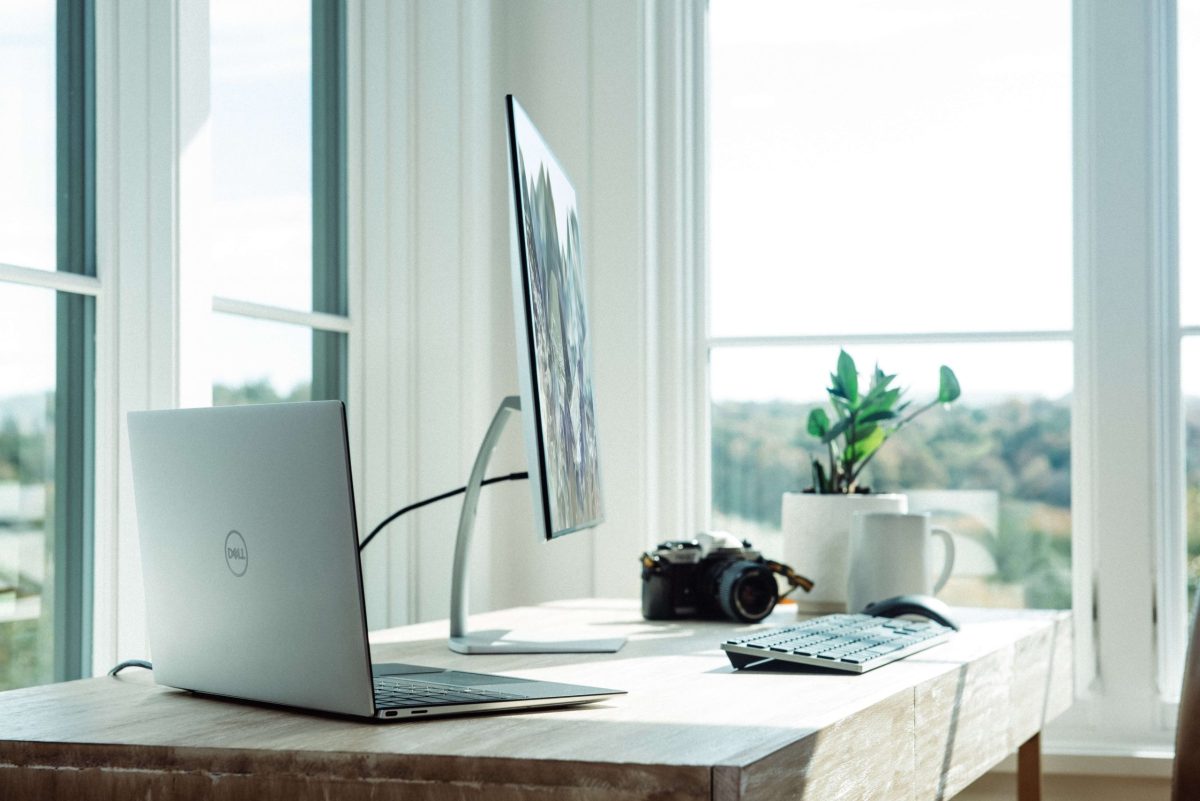 Dell laptop, monitor, and keyboard on desk with white background